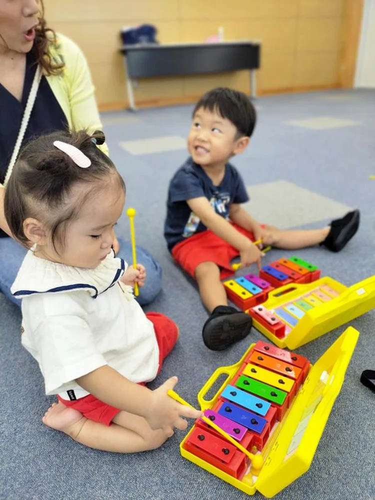 教室でカラフルな楽器を鳴らす子どもたち
