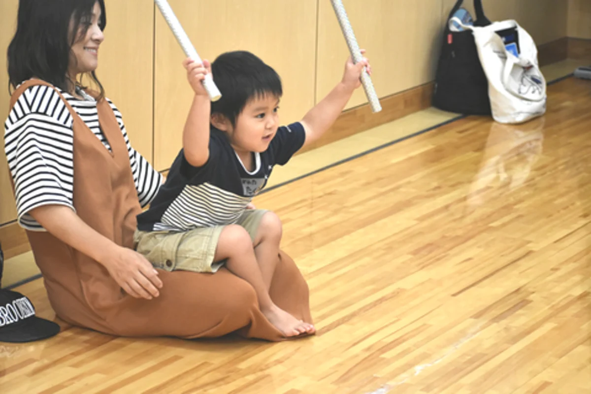 保護者と一緒にスティックを持ち、音楽に合わせて参加するお子さん