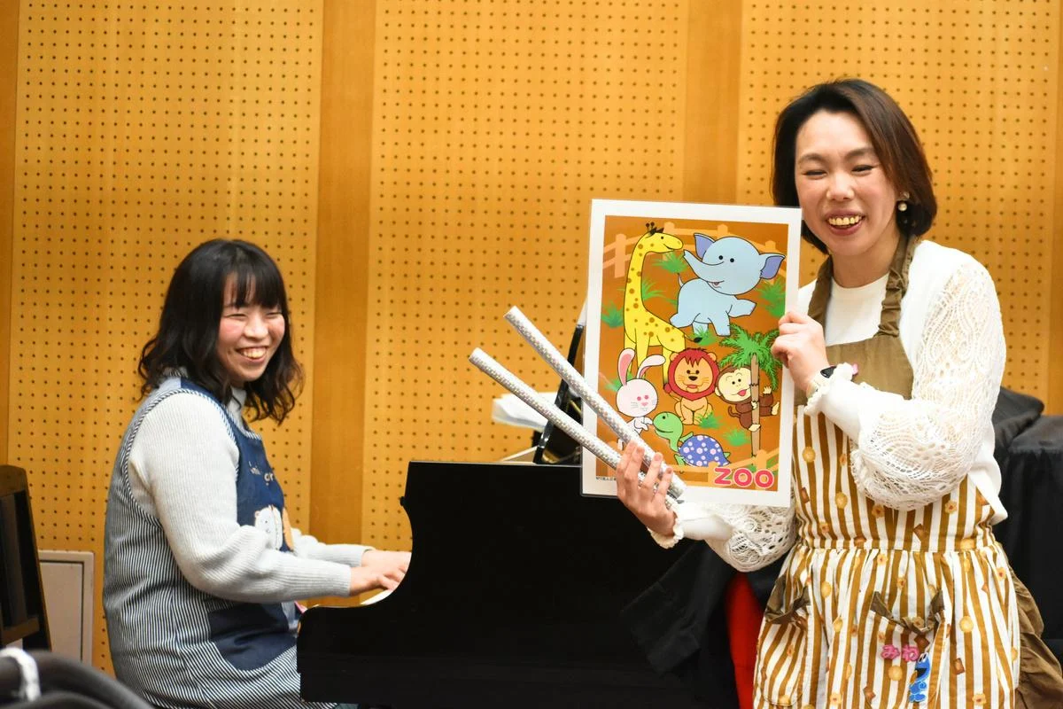 グランドピアノと英語絵本を使う2人の講師